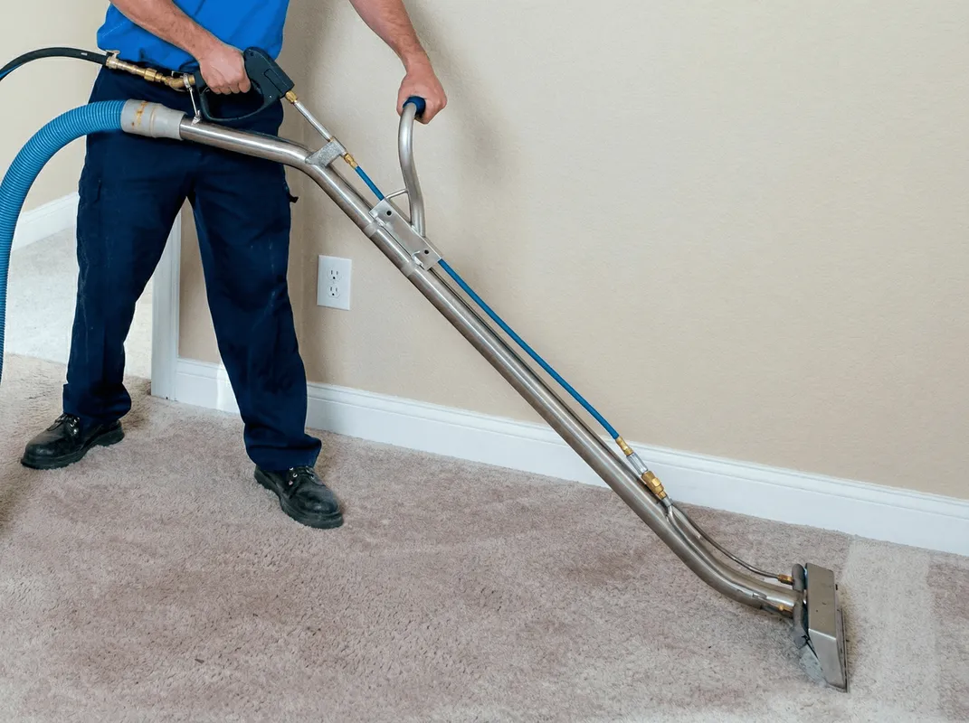 Professional operating a liquid removal machine on a carpeted floor in Knoxville, TN